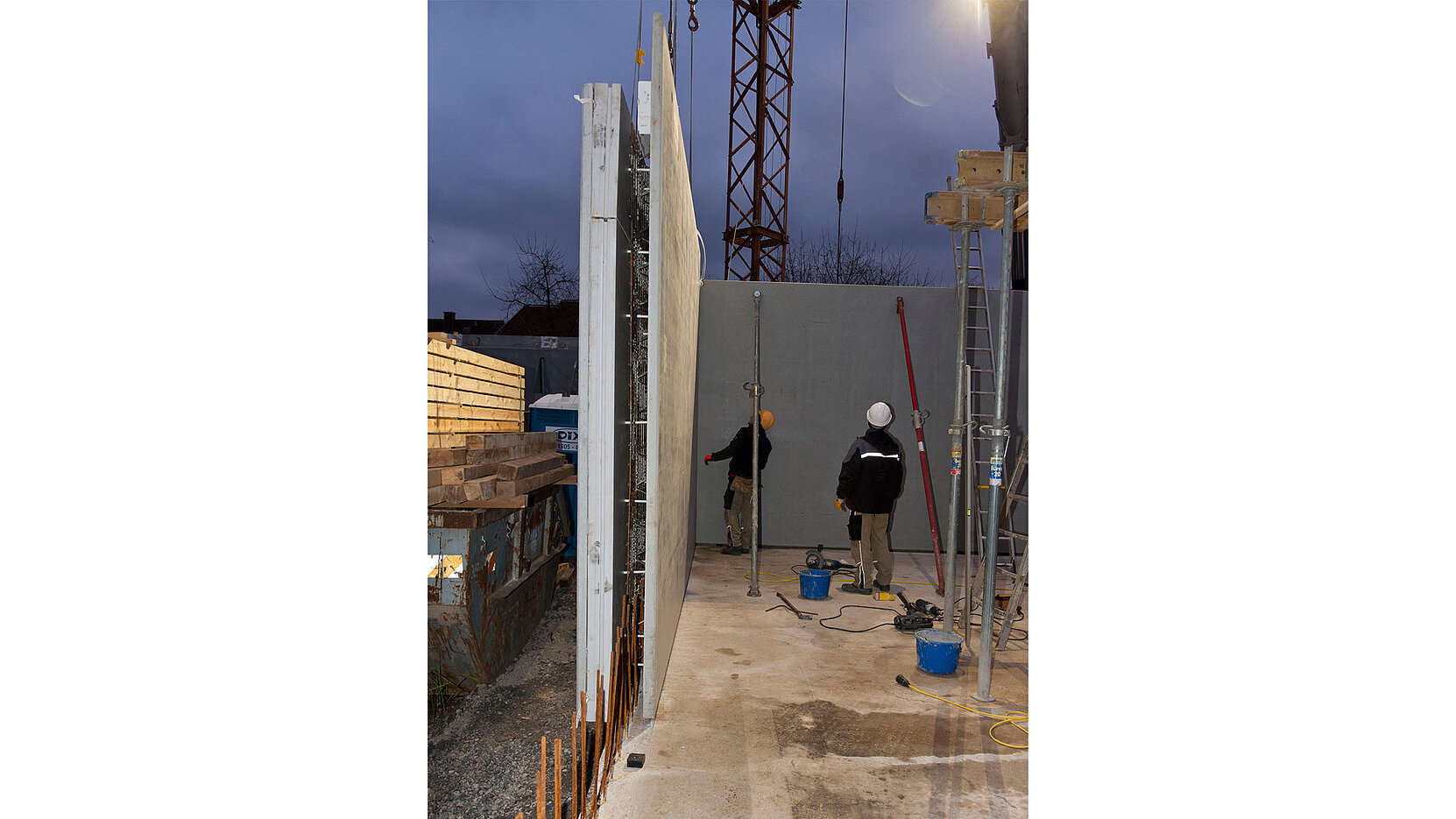 BIL_PRESSE_Versetzen Elementwand_16z9_FHD.jpg Moving an element wall by crane on the construction site.